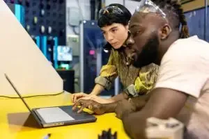 Engineers operating industrial 3D printing equipment in a workshop